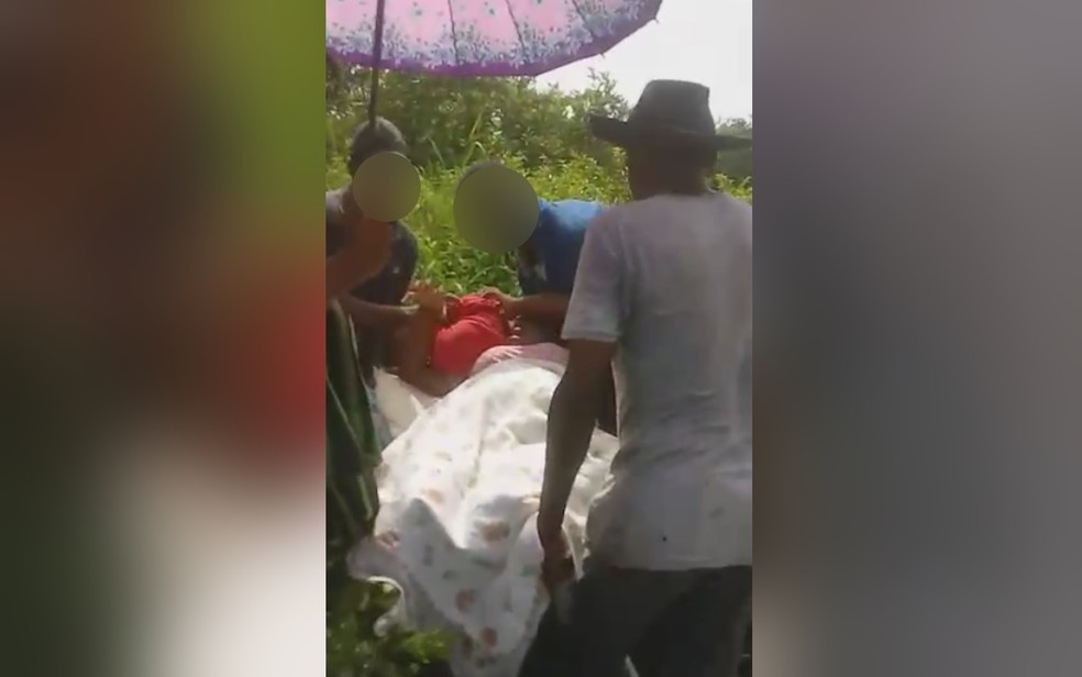 Vizinhos carregam grávida que passou mal em carrinho de mão por causa de atoleiro em São Domingos
