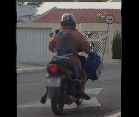 Mãe amarra criança ao corpo para andar de moto